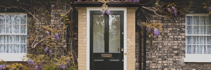 black-front-door-with-glazing-on-beautiful-stone-house