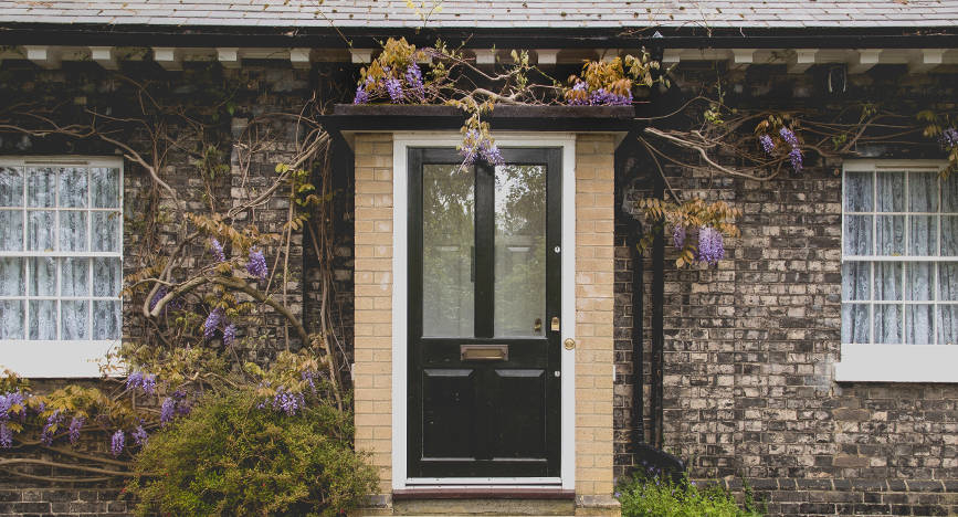 black-front-door-with-glazing-on-beautiful-stone-house