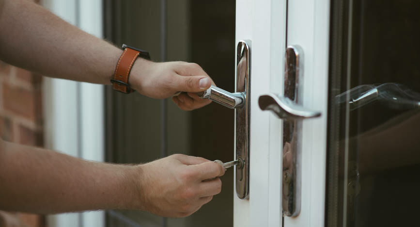 man-locking-patio-door-with-key