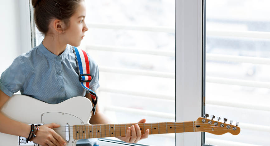 Girl Playing Instrument in Front of Acoustic Glass Window